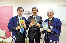 左から、200号を手にする水原康晴副編集長、創刊号を手にする村岡安廣理事長、組合創立60周年記念号（169号）を手にする諸岡靖彦編集長